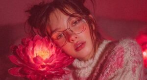 Una mujer en un jardín mágico sostiene una flor brillante que simboliza la elección de su primer vibrador o juguete sexual en Cali, Colombia